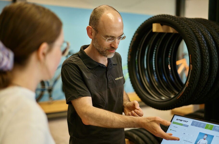 A velotraum employee explains the measurement results displayed on a screen to the customer